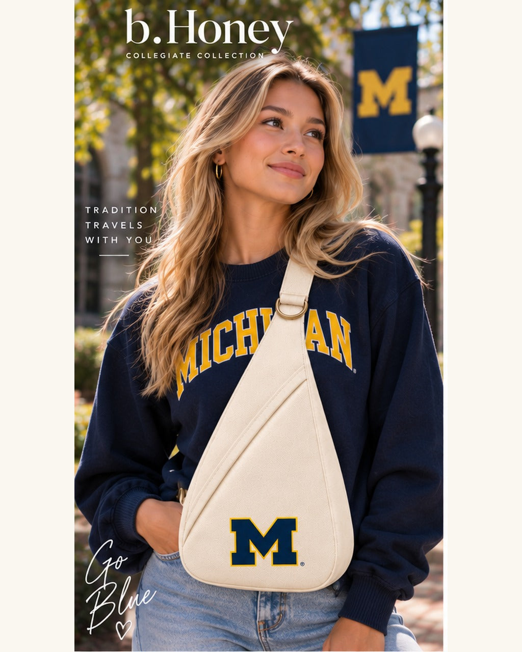 Model on campus wearing the ivory University of Michigan Honey Sling crossbody with navy and maize block M
