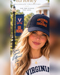 Female model wearing the navy University of Virginia Honey Lid trucker hat with orange Grounds For Trouble embroidery
